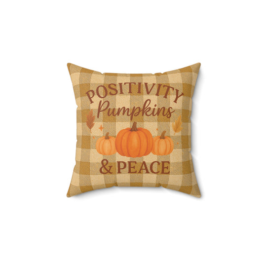 Decorative pillow with 'Positivity Pumpkins & Peace' text and pumpkin illustrations on a checkered background.