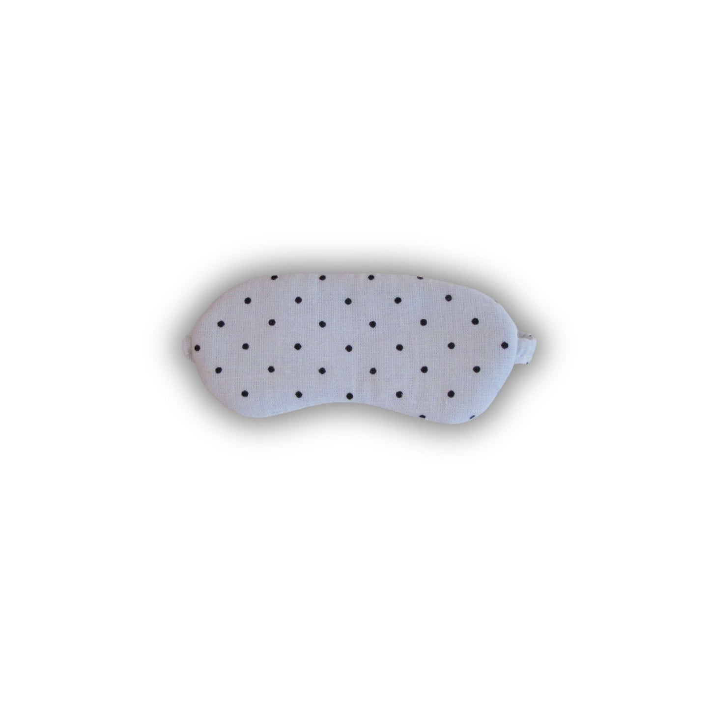 White sleep mask with black polka dots on a white background