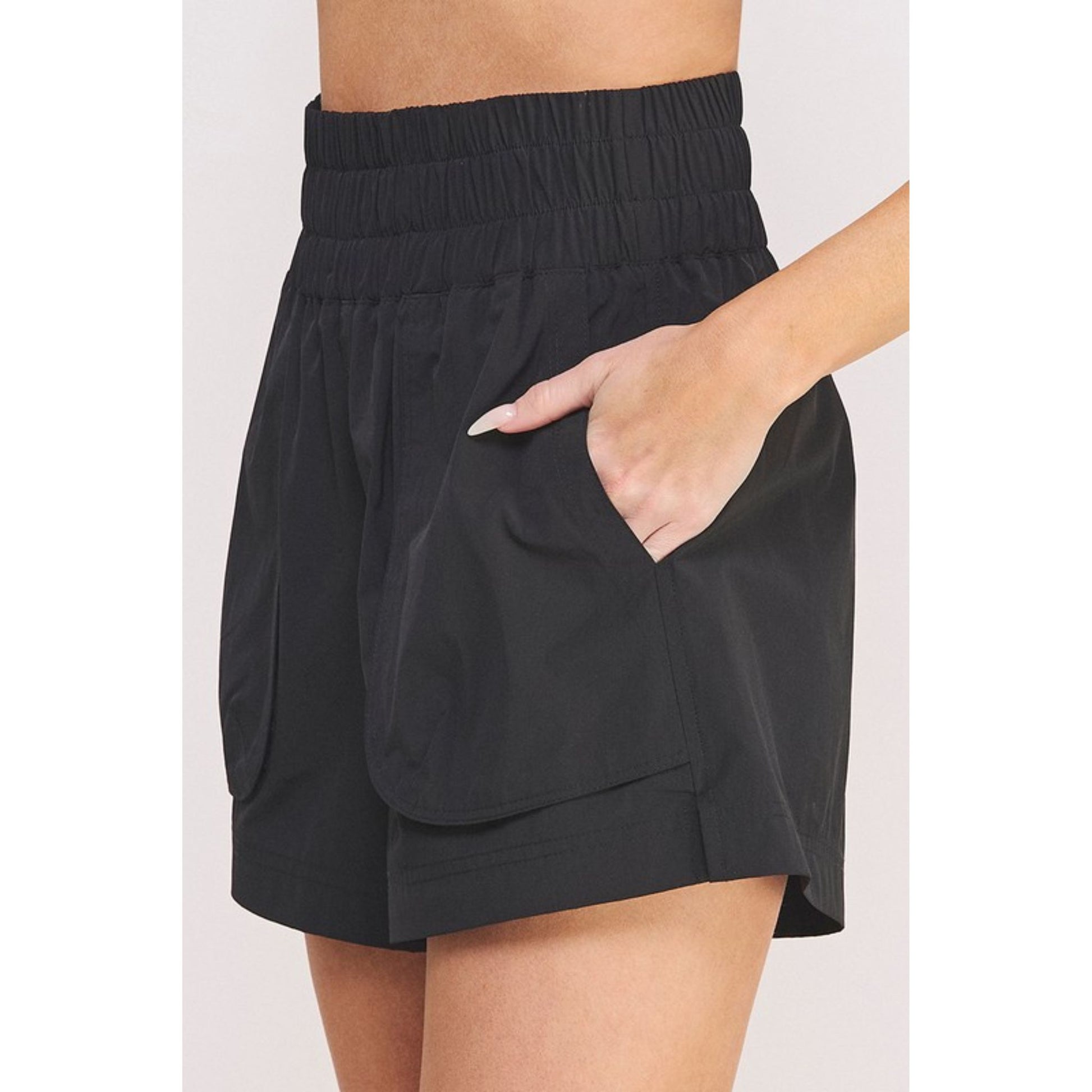 Black shorts worn by a person on a white background