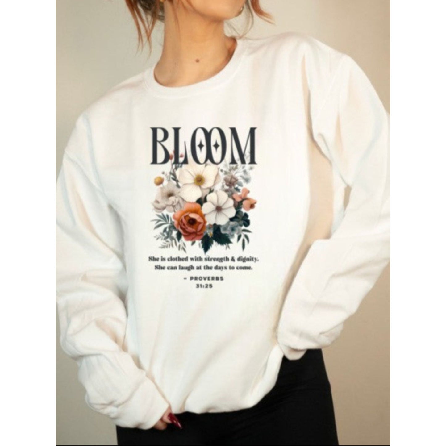 White sweatshirt with floral design and text on a neutral background