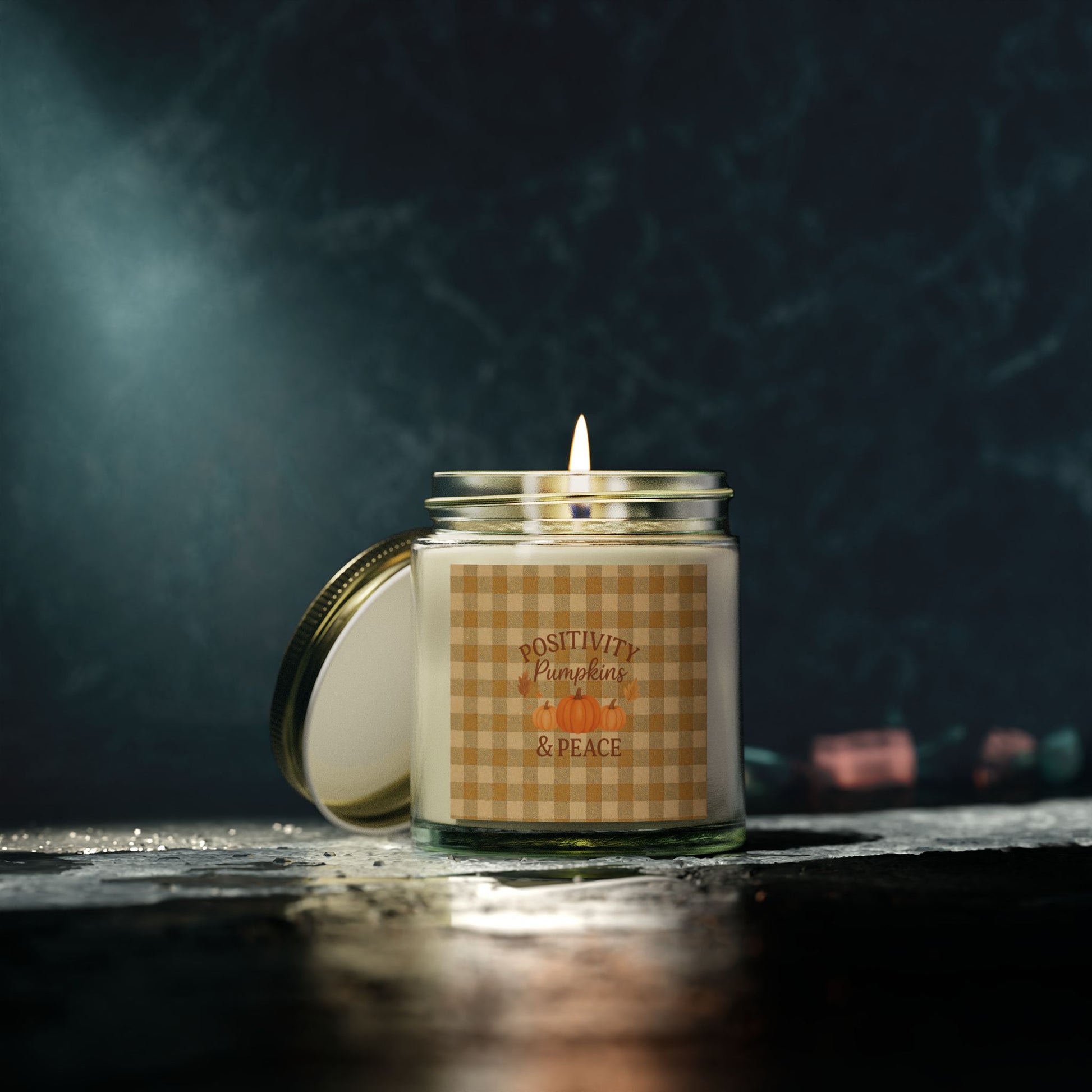 Candle in a glass jar with a checkered label on a dark background