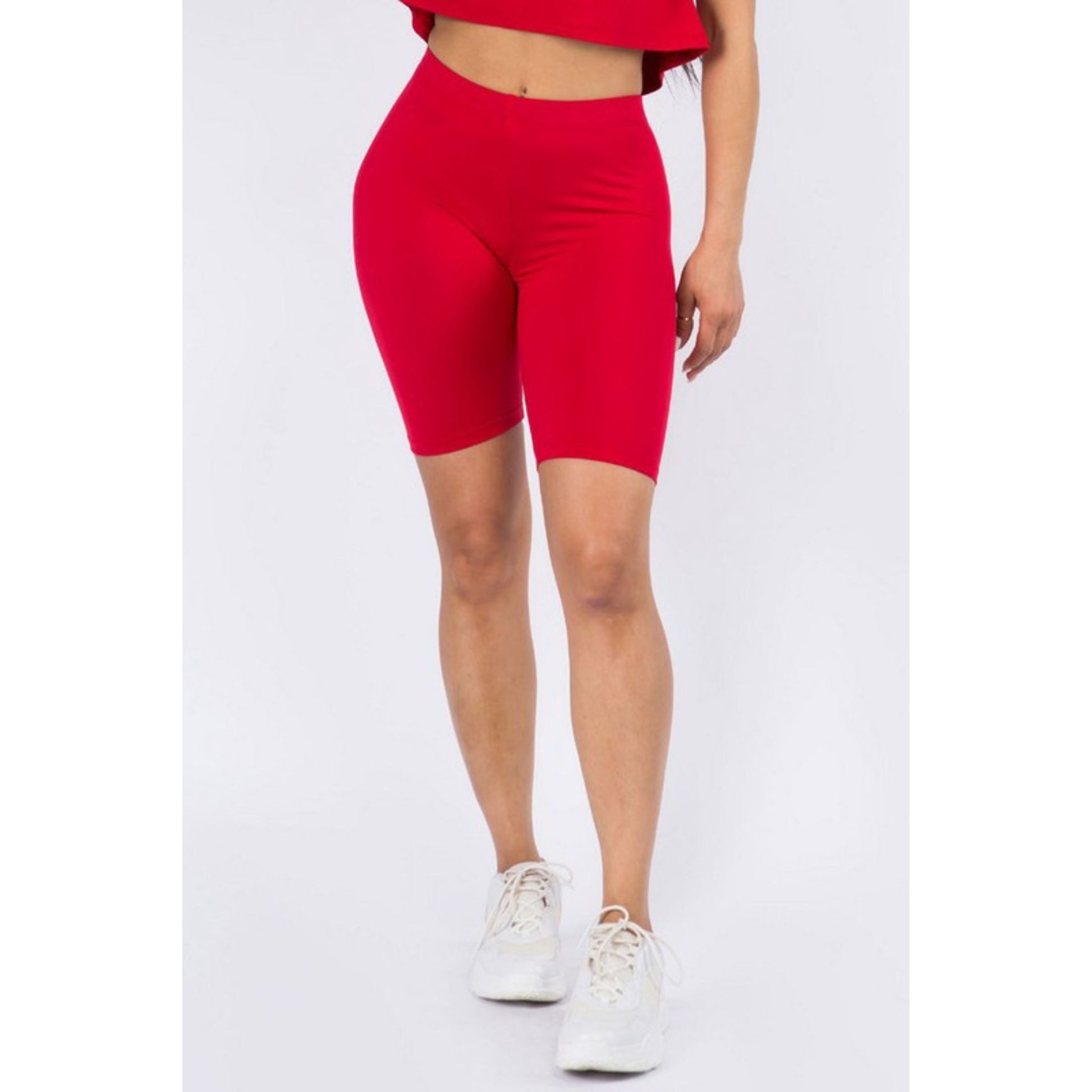 Red bike shorts worn by a person on a white background