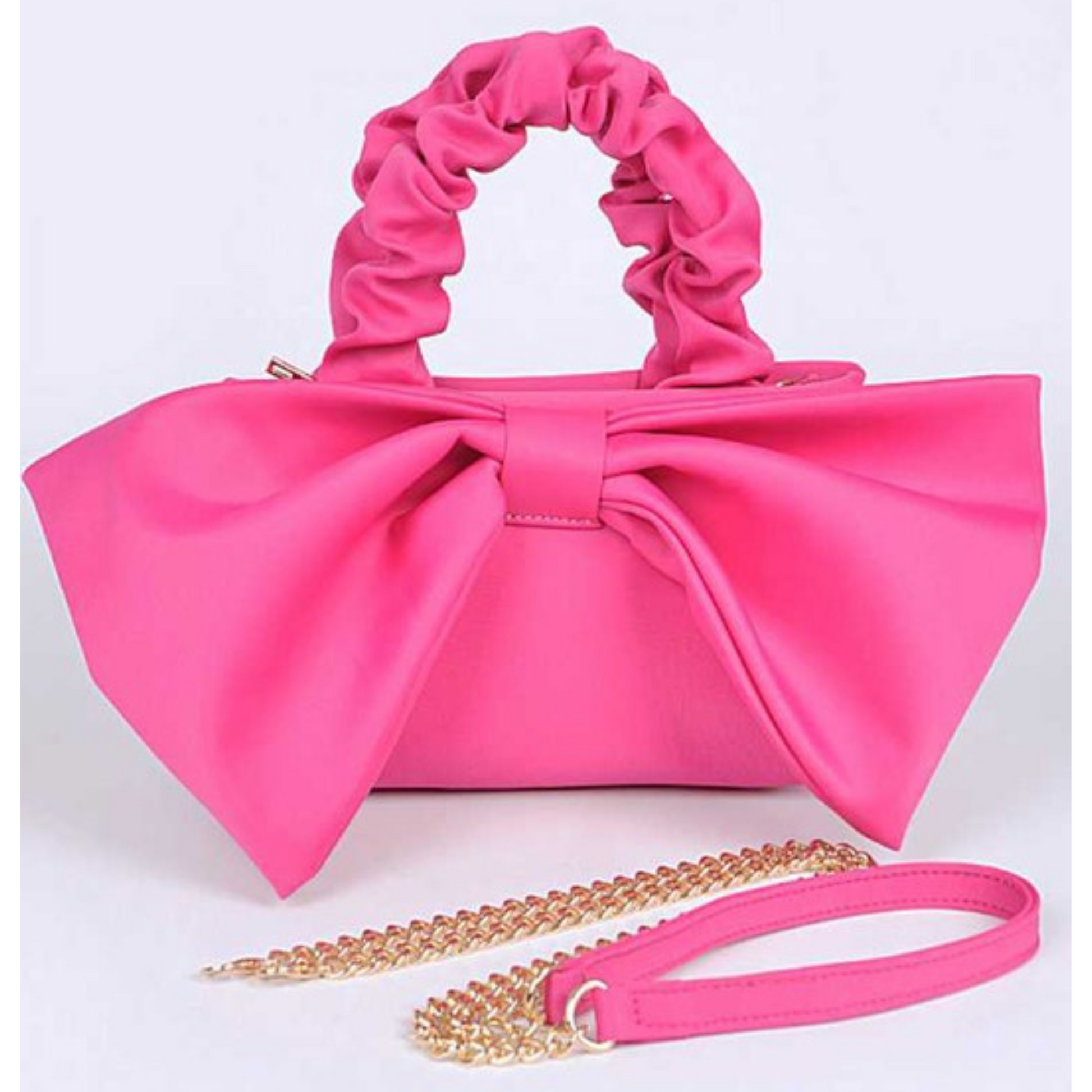 Pink handbag with a large bow and gold chain strap on a white background
