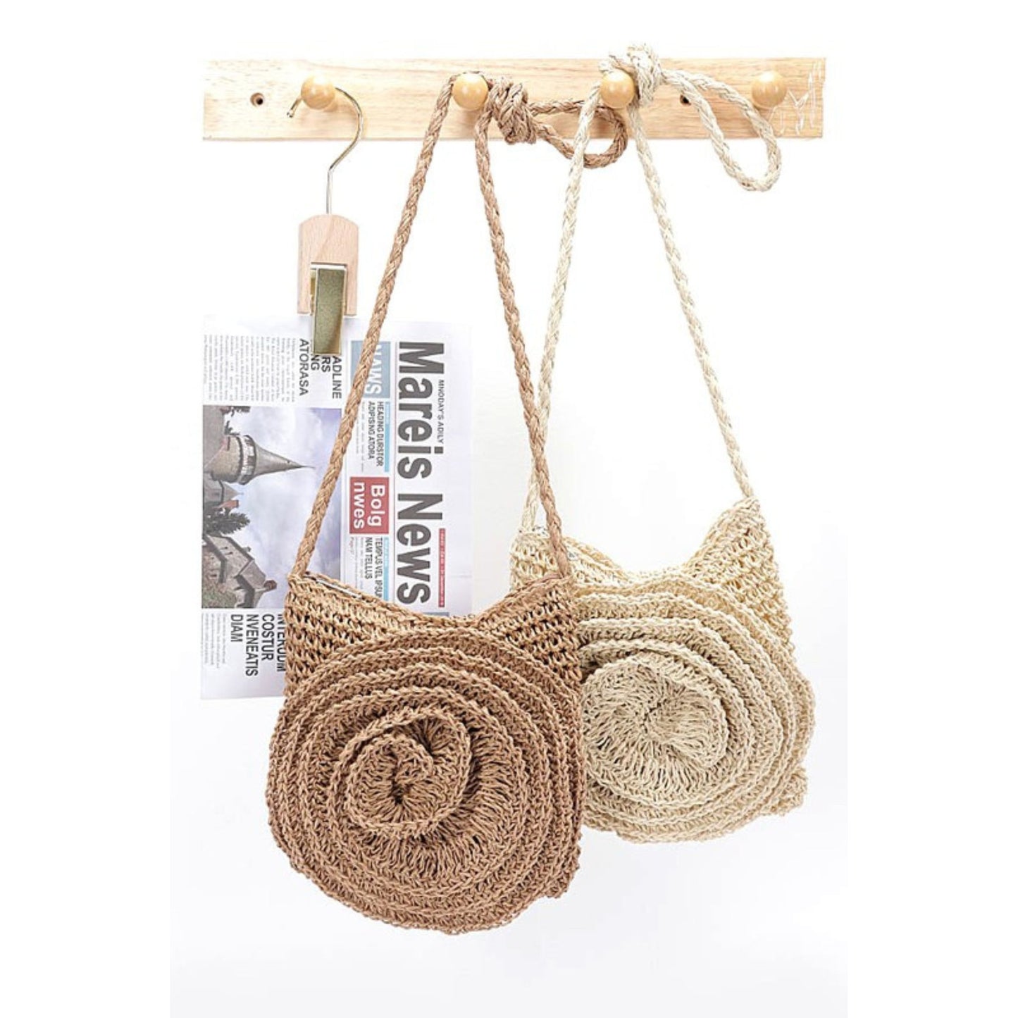 Crocheted bag with a wooden stick and newspaper on a white background
