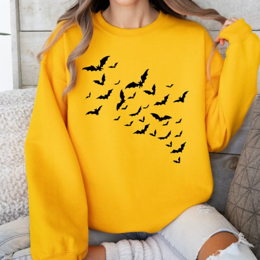 Person wearing a yellow sweatshirt with black bat patterns