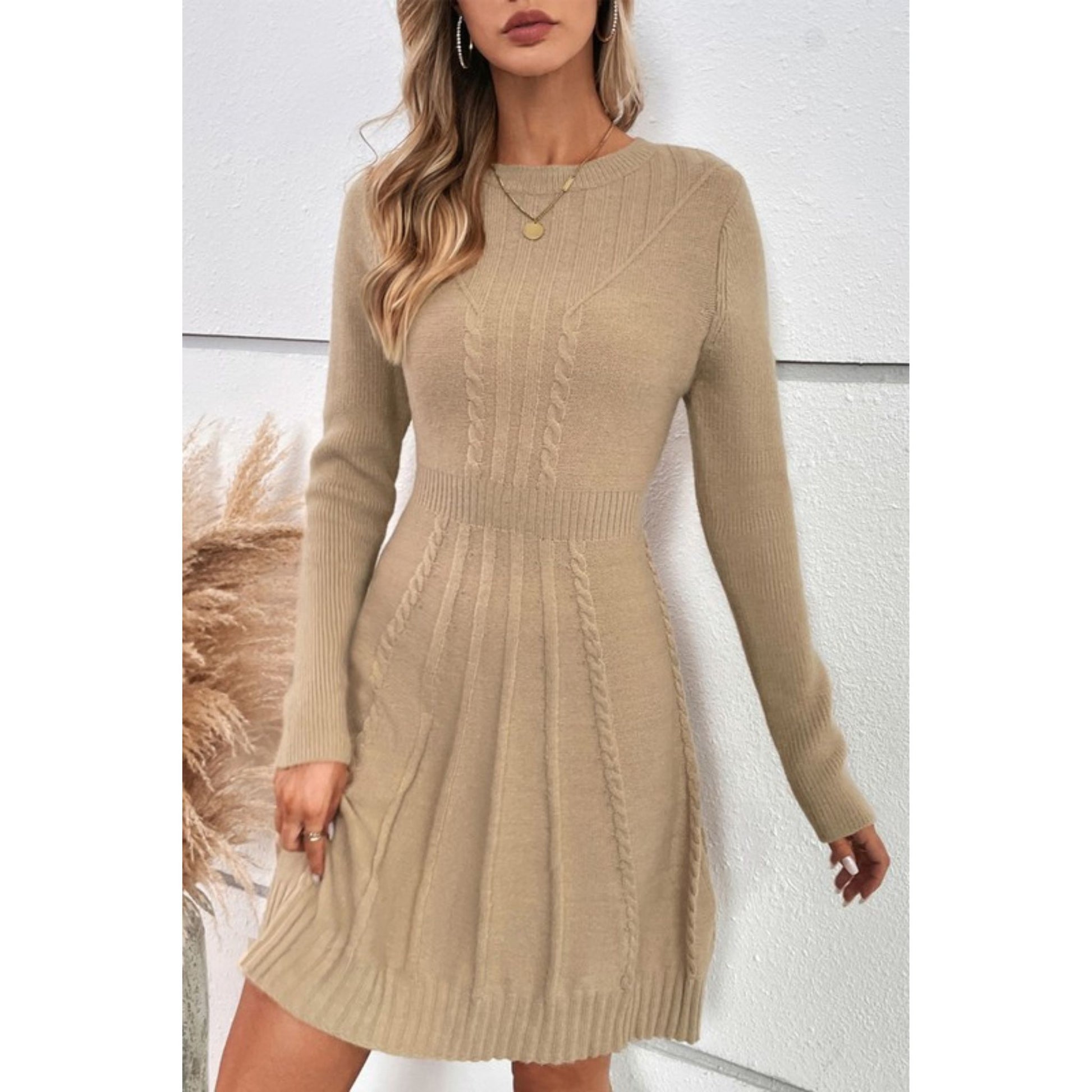 Woman wearing a beige cable knit dress against a white background