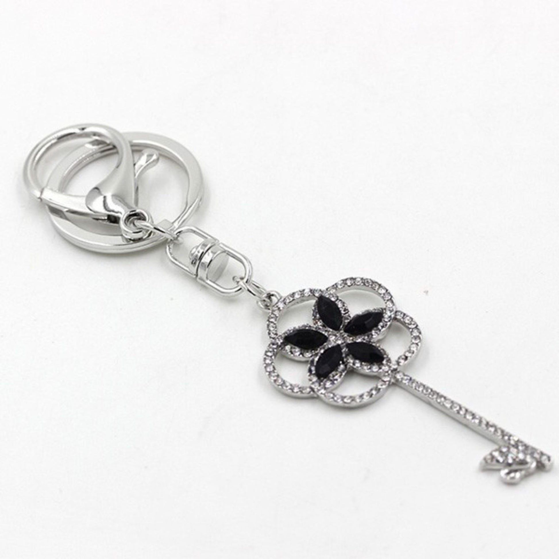 Silver key-shaped keychain with a black clover design on a white background
