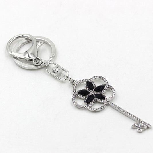 Silver key-shaped keychain with a black clover design on a white background
