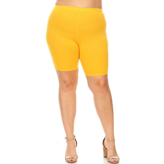 Yellow biker shorts worn by a person on a white background