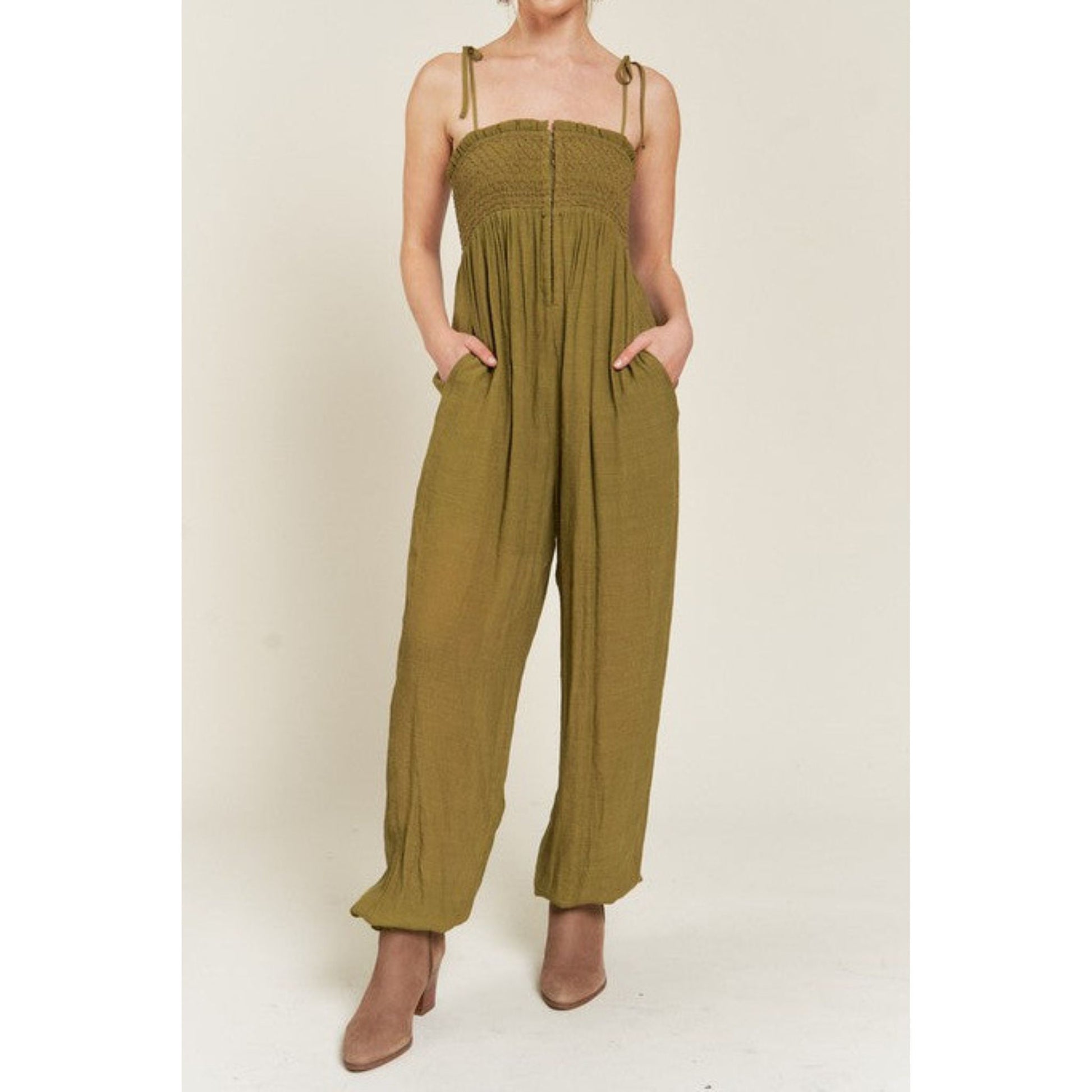 Person wearing a green jumpsuit on a plain background