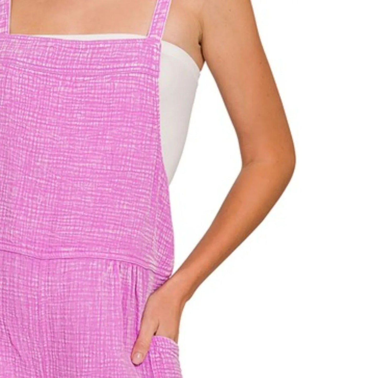 Close-up of a pink checkered dress with a white underlayer on a plain background