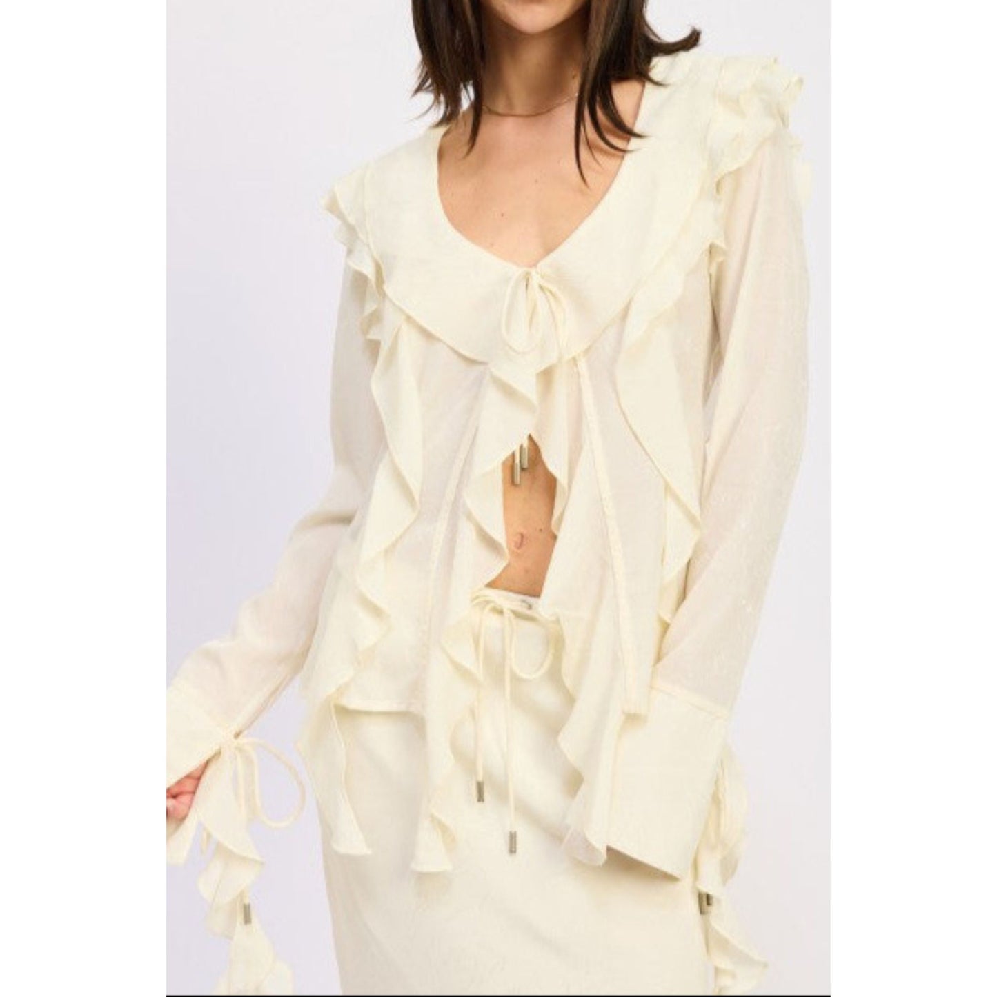 Woman wearing a light yellow ruffled outfit on a white background