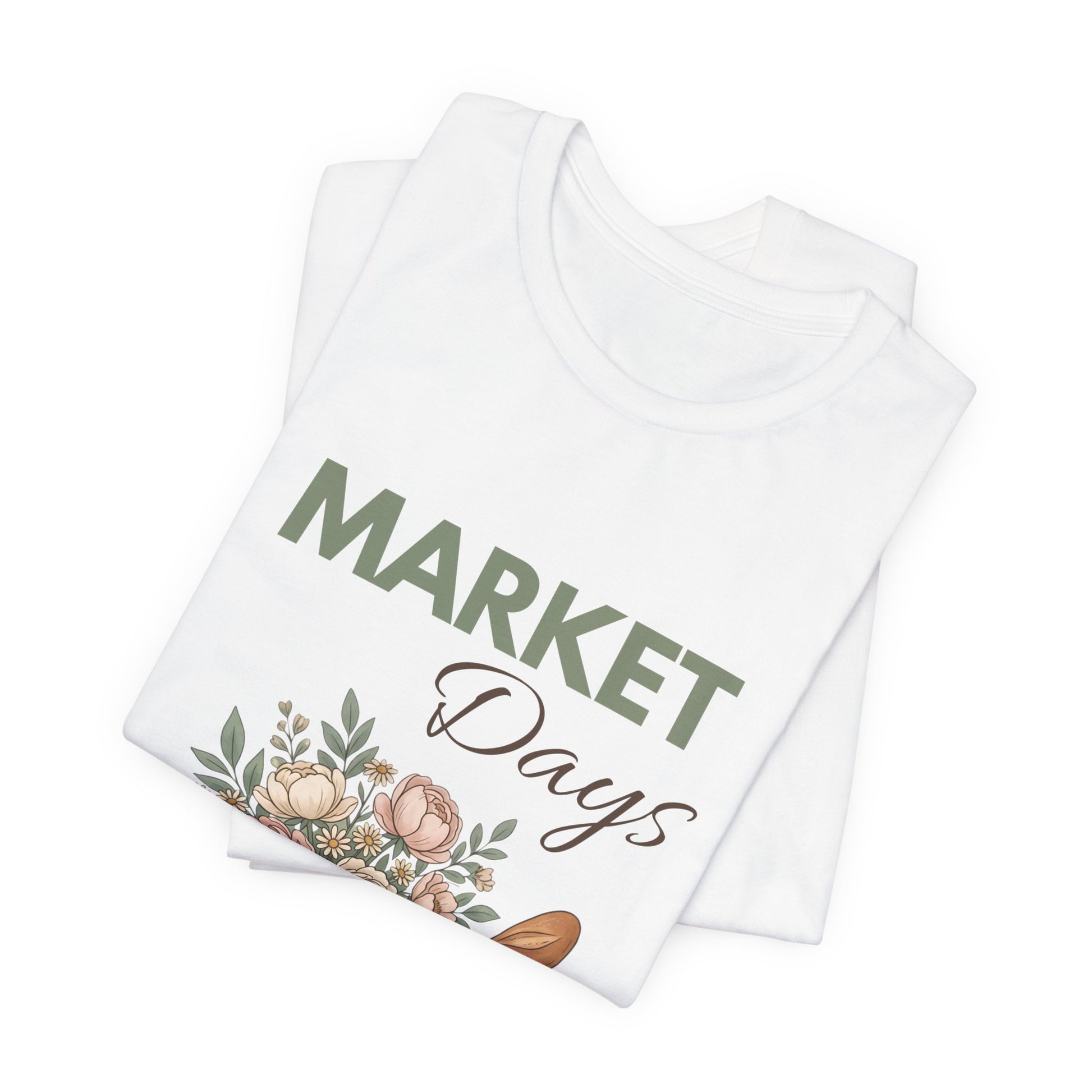 A folded white t-shirt with 'Market Days' on the front.