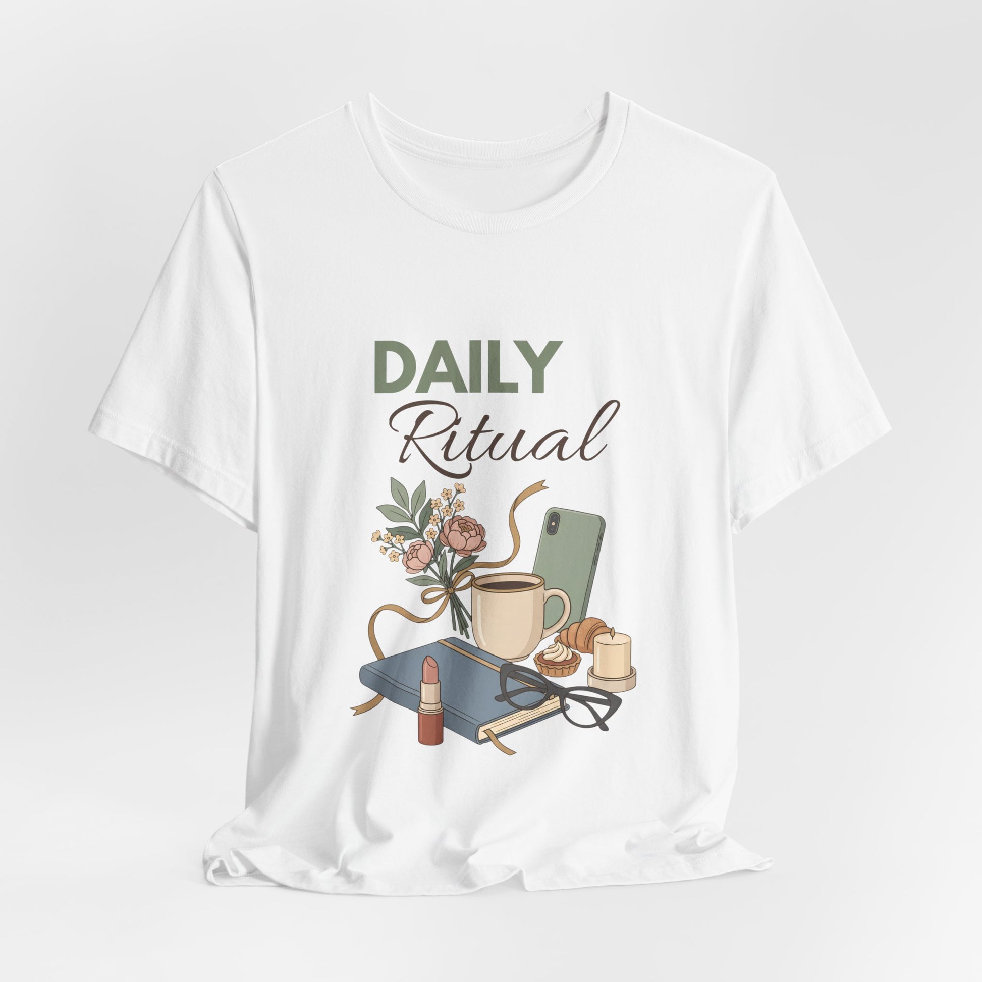 White t-shirt with 'Daily Ritual' graphic design featuring a cup, phone, and other items on a white background.