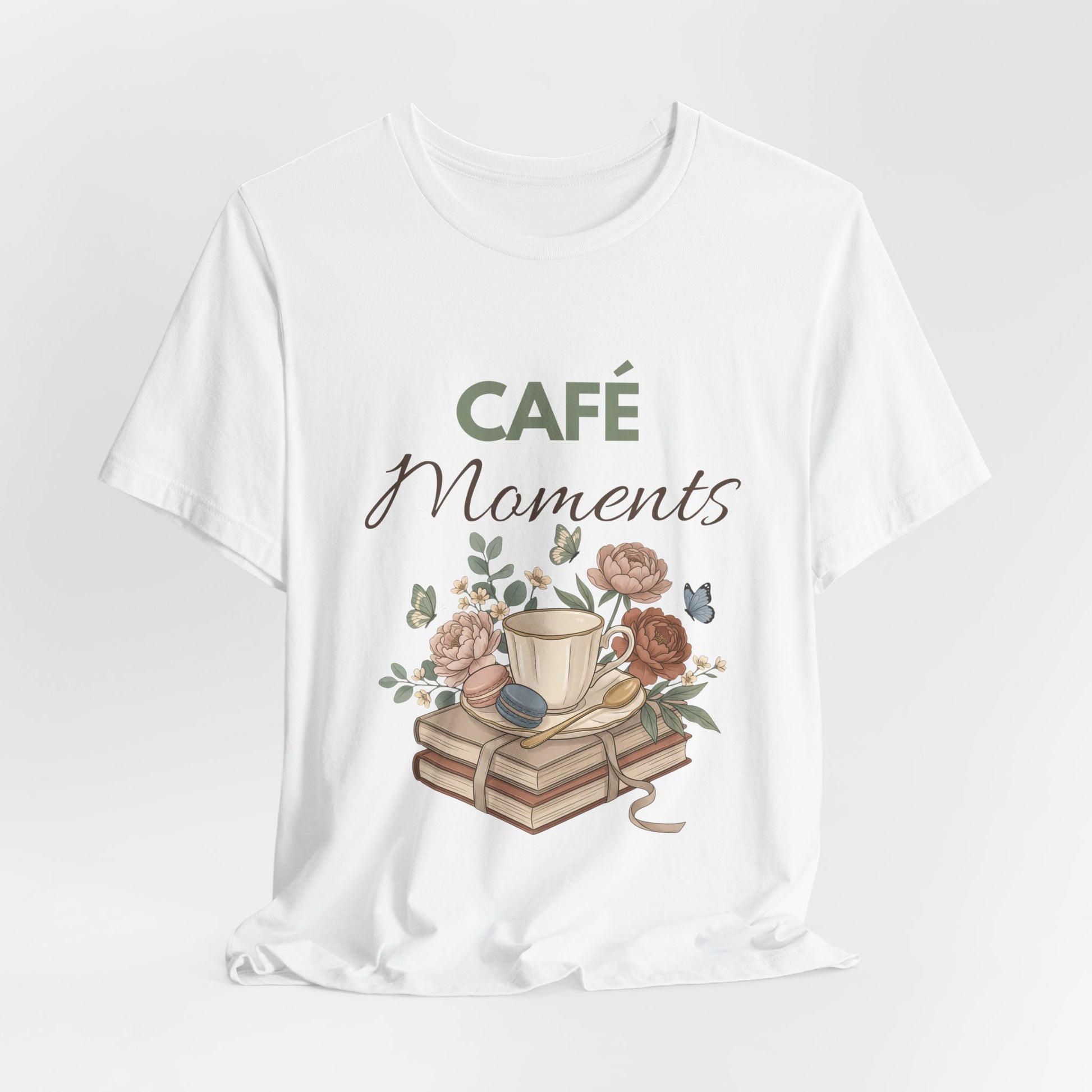 White t-shirt with 'Café Moments' design featuring a cup, books, and flowers on a white background