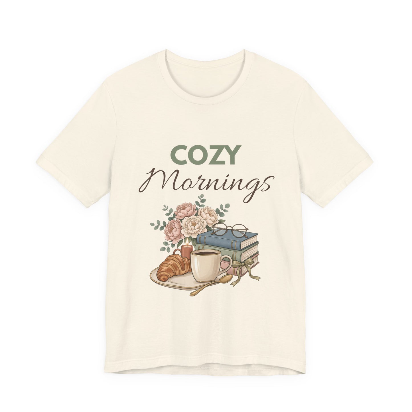 Natural colored t-shirt with 'Cozy Mornings' graphic featuring a cup, croissant, books, and flowers on a white background.
