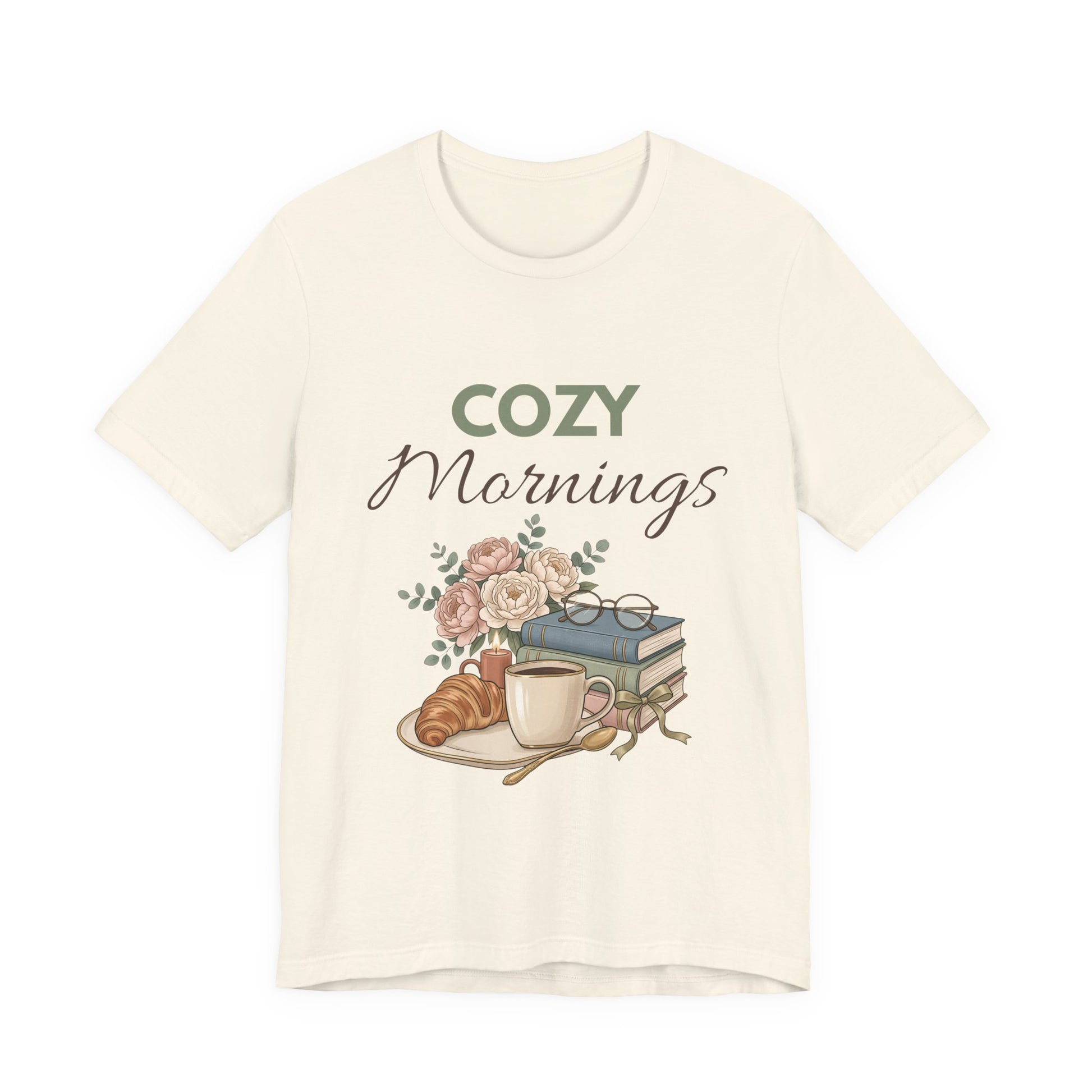 Natural colored t-shirt with 'Cozy Mornings' graphic featuring a cup, croissant, books, and flowers on a white background.