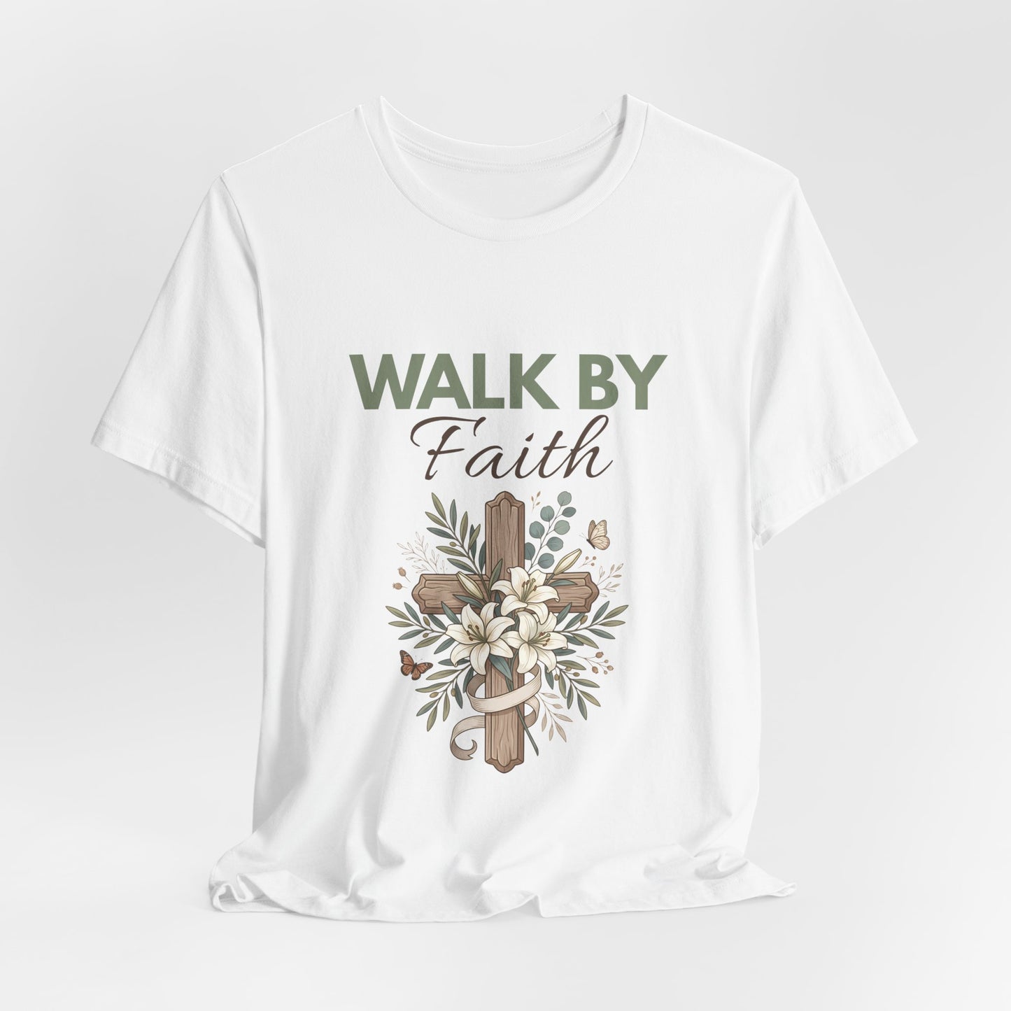 White t-shirt with 'Walk by Faith' text and cross design on a light gray background