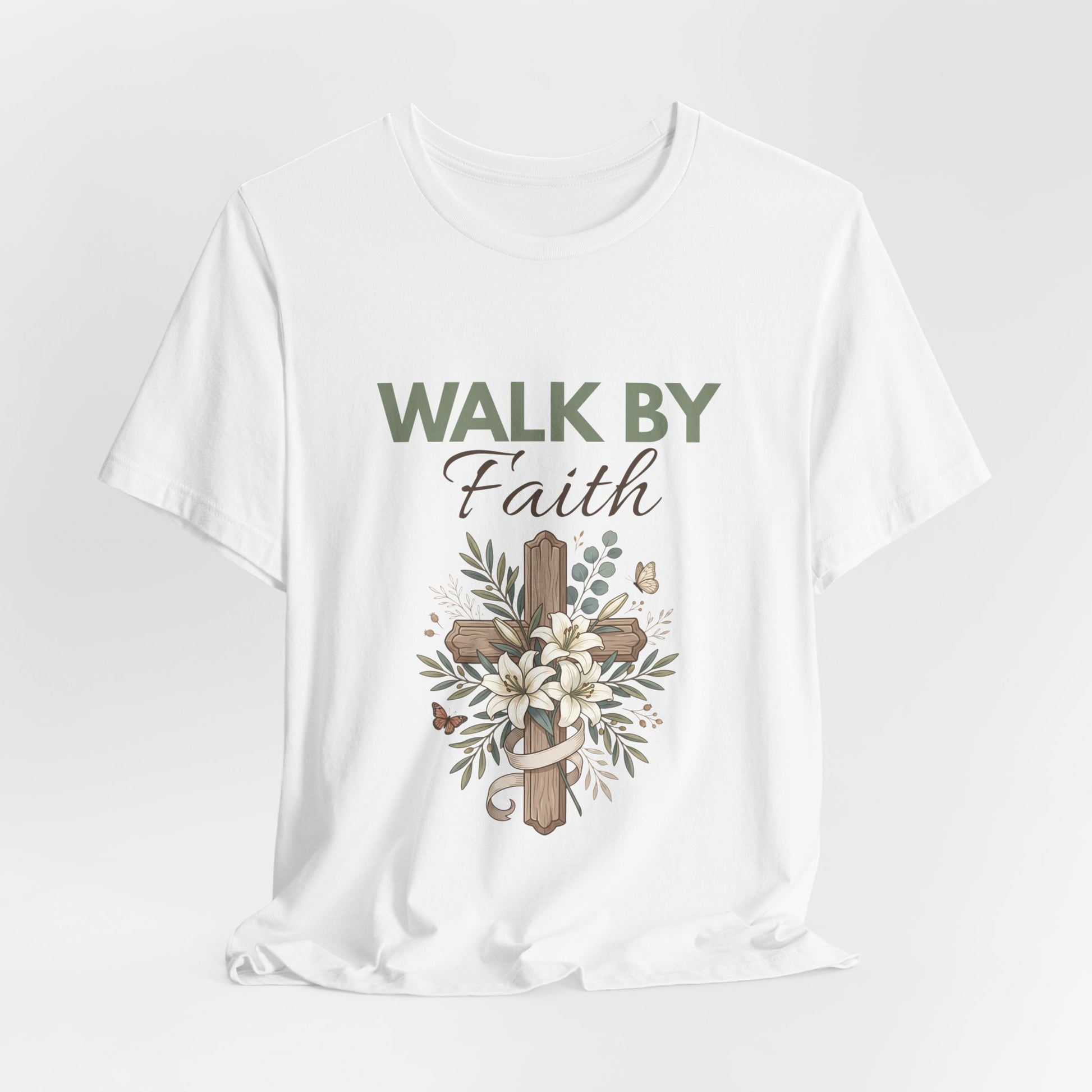 White t-shirt with 'Walk by Faith' text and cross design on a light gray background