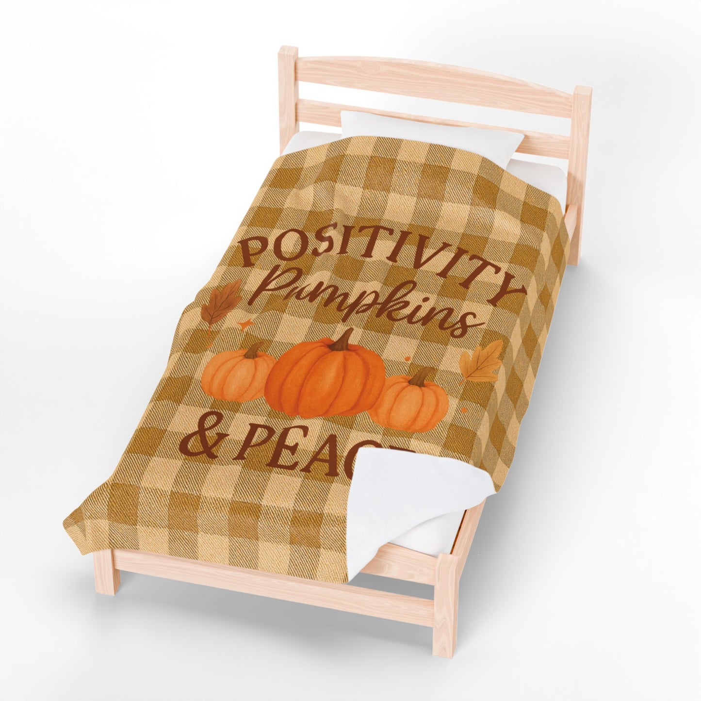 Checkered blanket with pumpkins and text on a bed