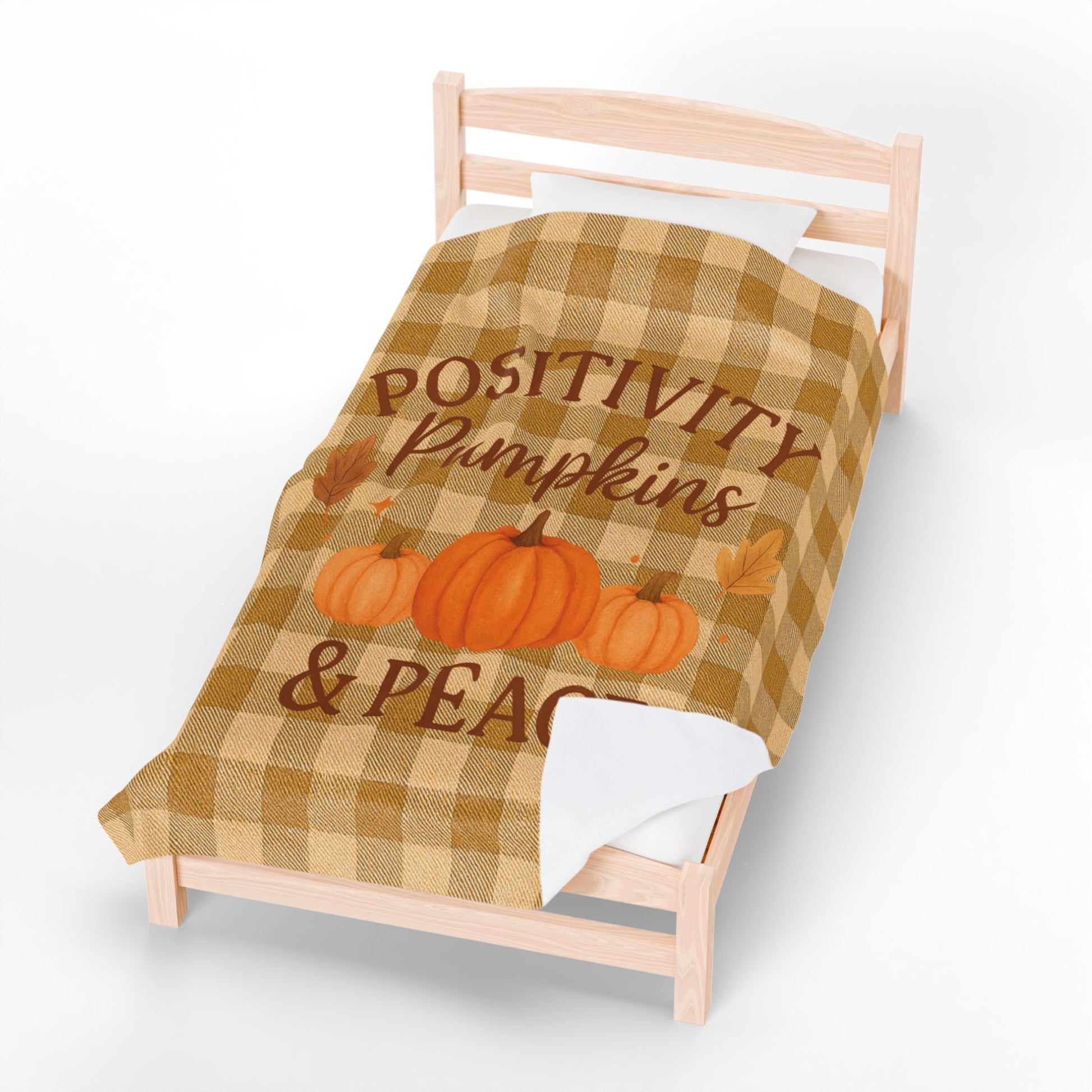 Checkered blanket with pumpkins and text on a bed