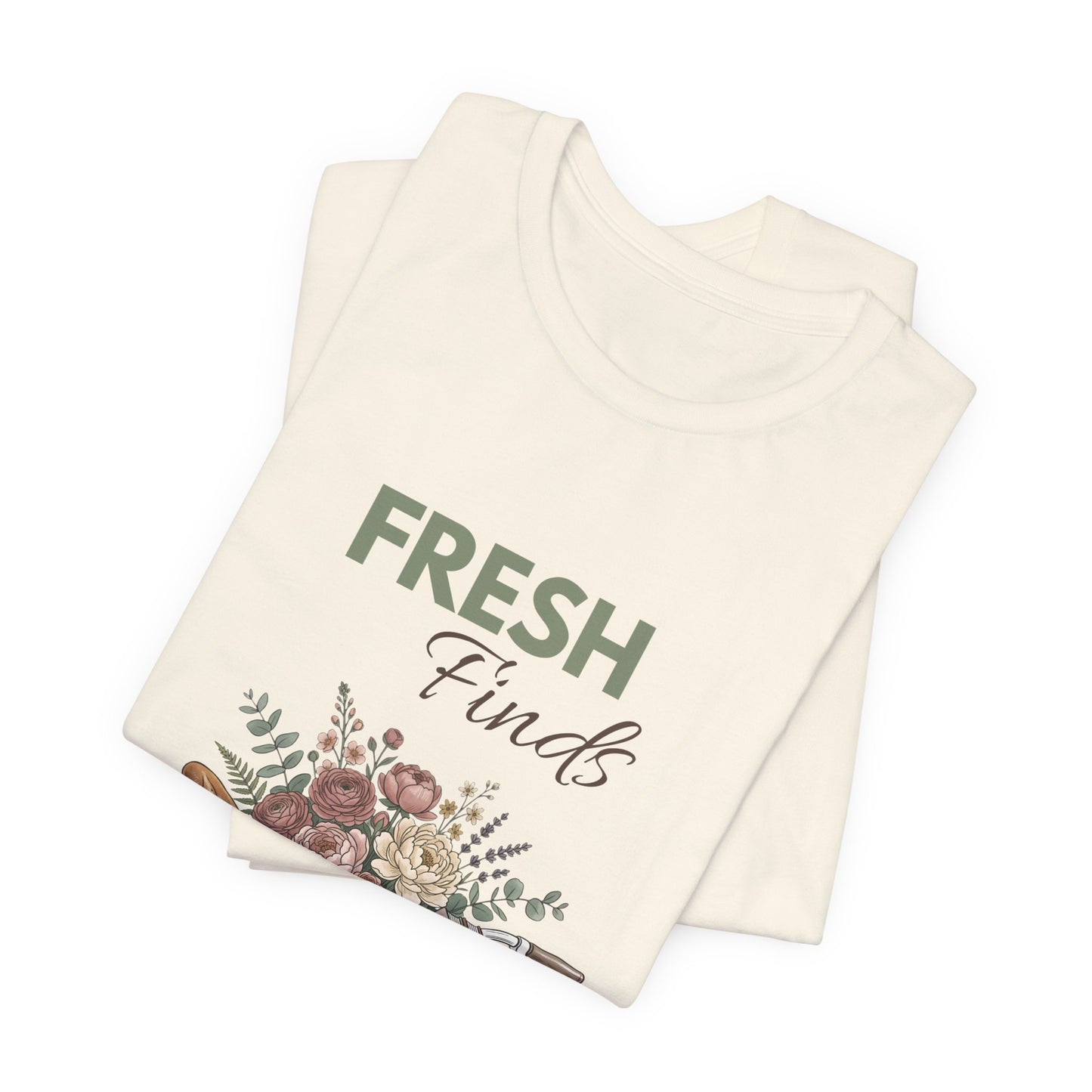 A folded natural colored t-shirt with 'FRESH Finds' on the front.