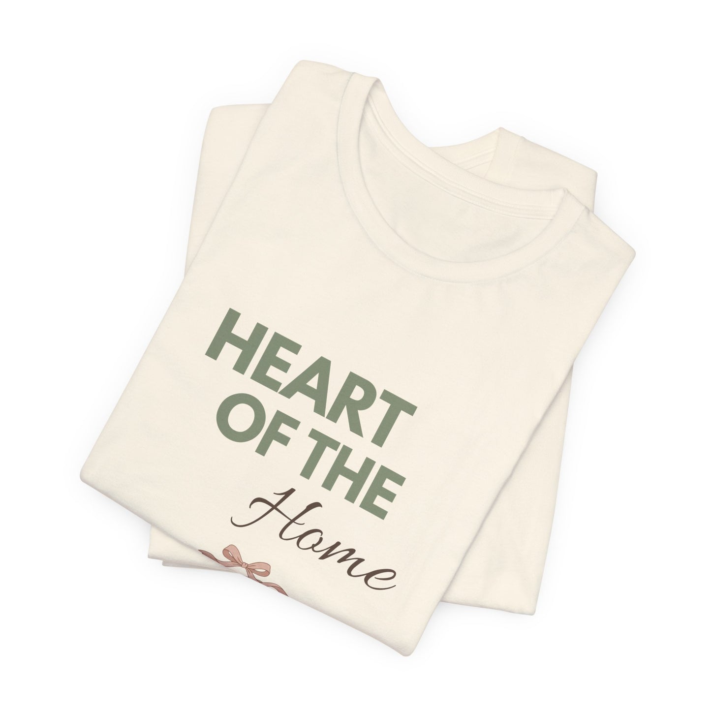 A folded natural colored t-shirt with 'HEART OF THE Home' on the front.