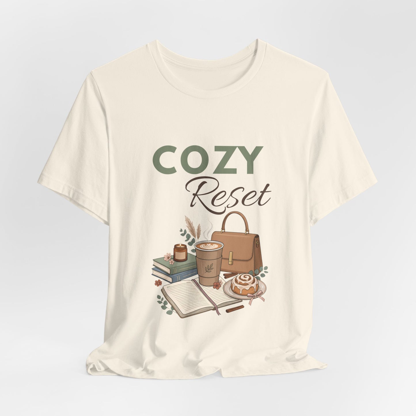 A hanging natural colored t-shirt with 'COZY Reset' on the front.
