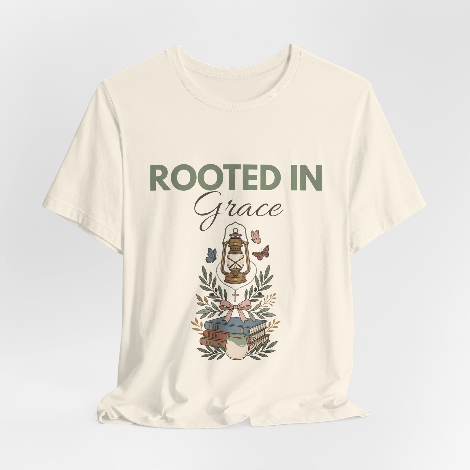 A natural colored t-shirt with 'Rooted in Grace' text and design on a light gray background