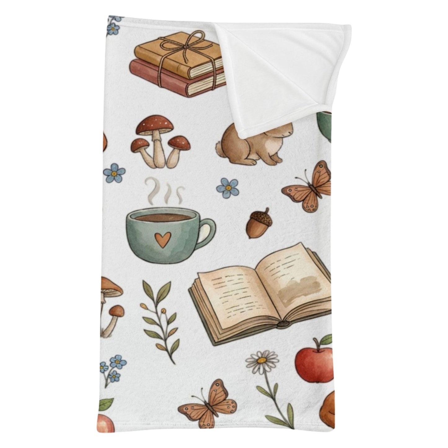 A white minky sleeping bag with a corner folded down, featuring a whimsical autumn-themed pattern with illustrated books, mushrooms, a mug, acorns, butterflies, flowers, and an apple, shown on a plain white background.