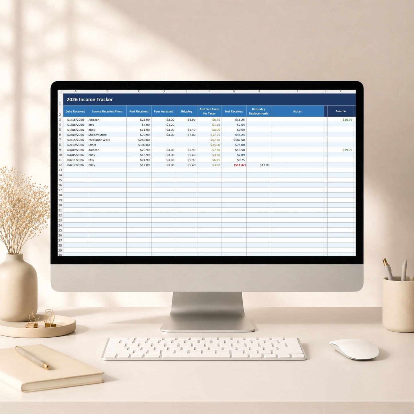 Computer monitor displaying an 'Income Tracker' spreadsheet on a desk with decor items.