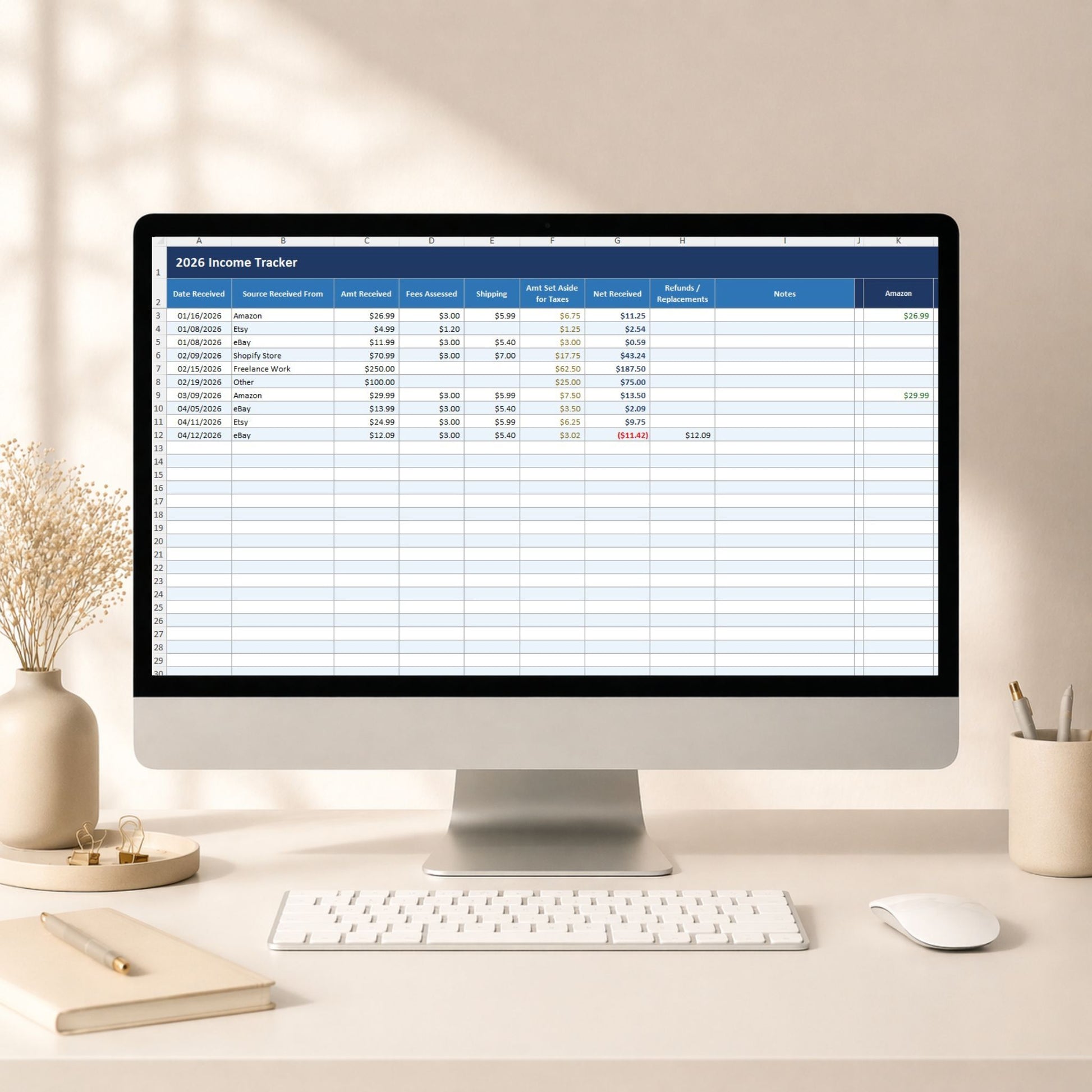 Computer monitor displaying an 'Income Tracker' spreadsheet on a desk with decor items.