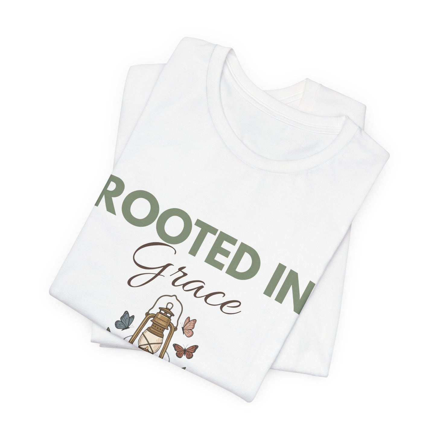 Folded white t-shirt with 'Rooted in Grace' text and illustrations on a white background
