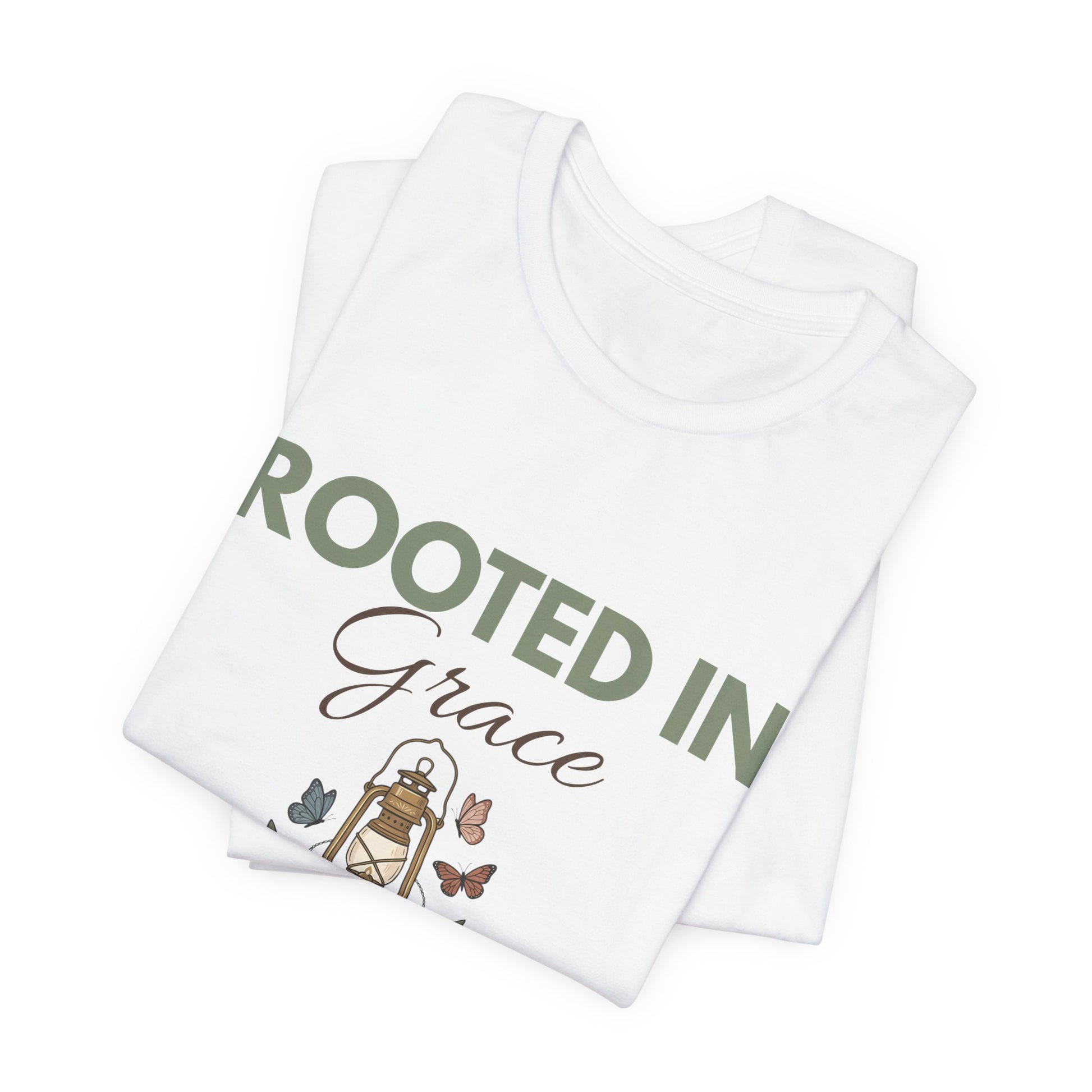 Folded white t-shirt with 'Rooted in Grace' text and illustrations on a white background