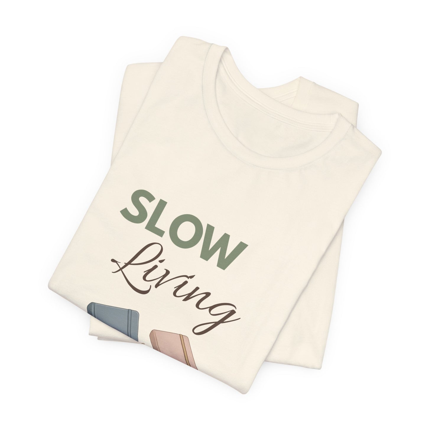 Folded natural colored t-shirt with 'Slow Living'.