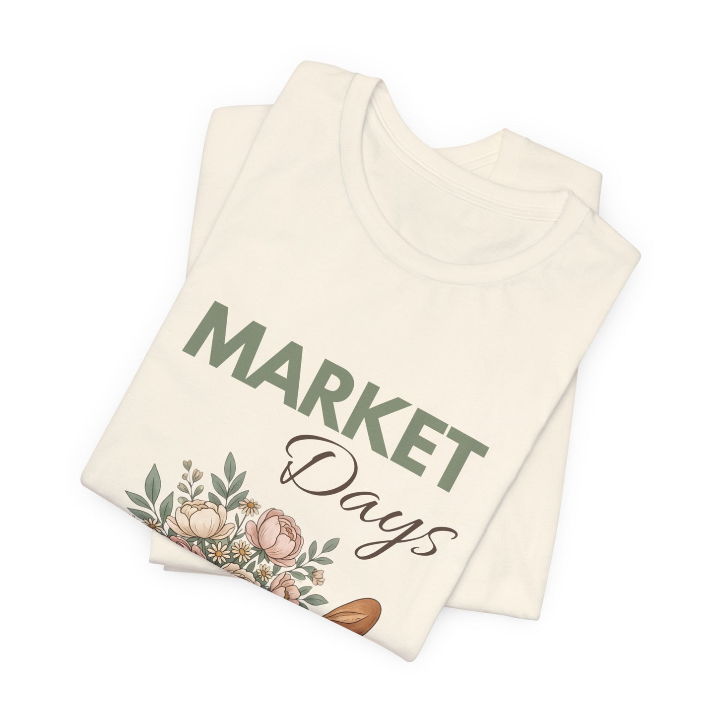 A folded natural colored t-shirt with 'Market Days' on the front.