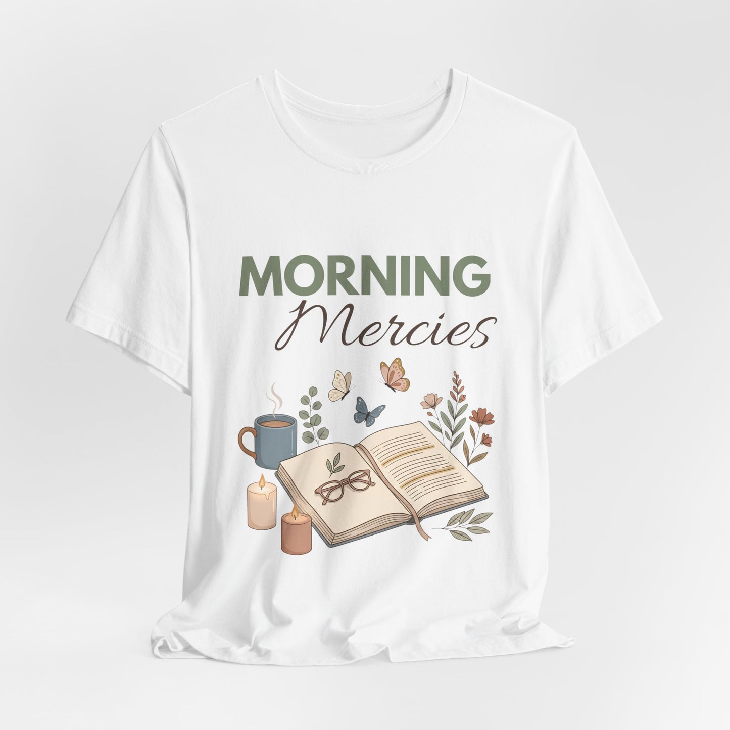White t-shirt with 'Morning Mercies' text and book, cup, and candle graphic on a white background