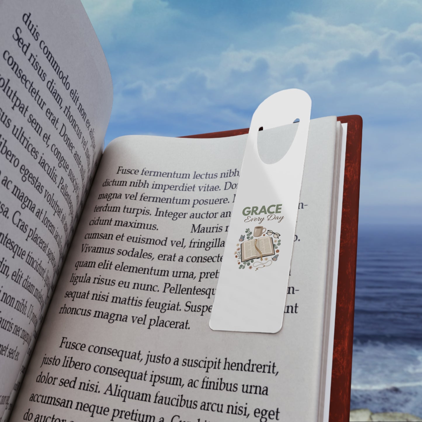 Open book with a bookmark featuring an open book with a mug, glasses, and cross on a chain.