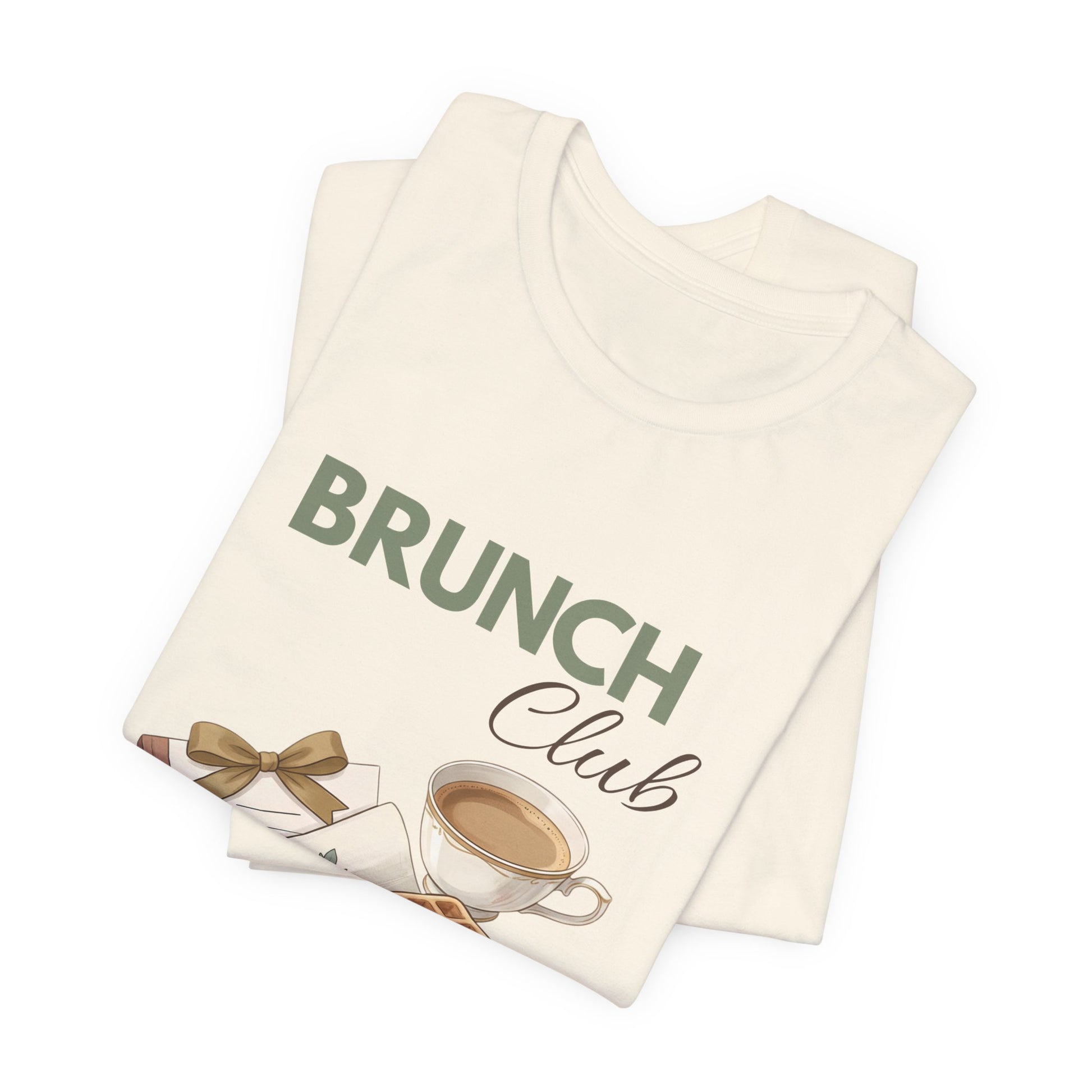 A folded natural colored t-shirt with 'BRUNCH Club' on the front.