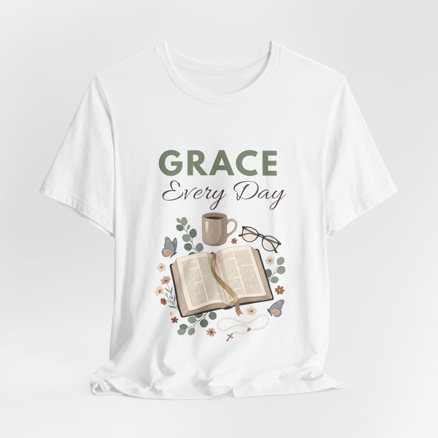 White t-shirt with 'Grace Every Day' text and book, cup, and glasses graphic on a white background