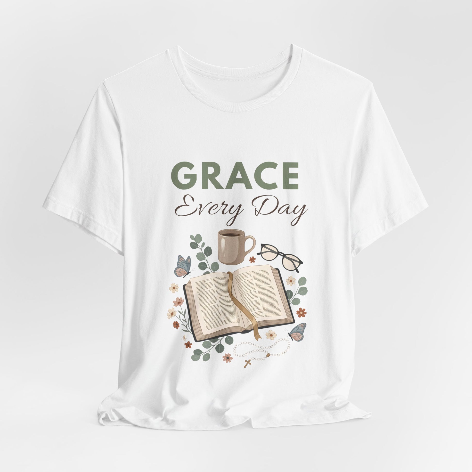 White t-shirt with 'Grace Every Day' text and book, cup, and glasses graphic on a white background