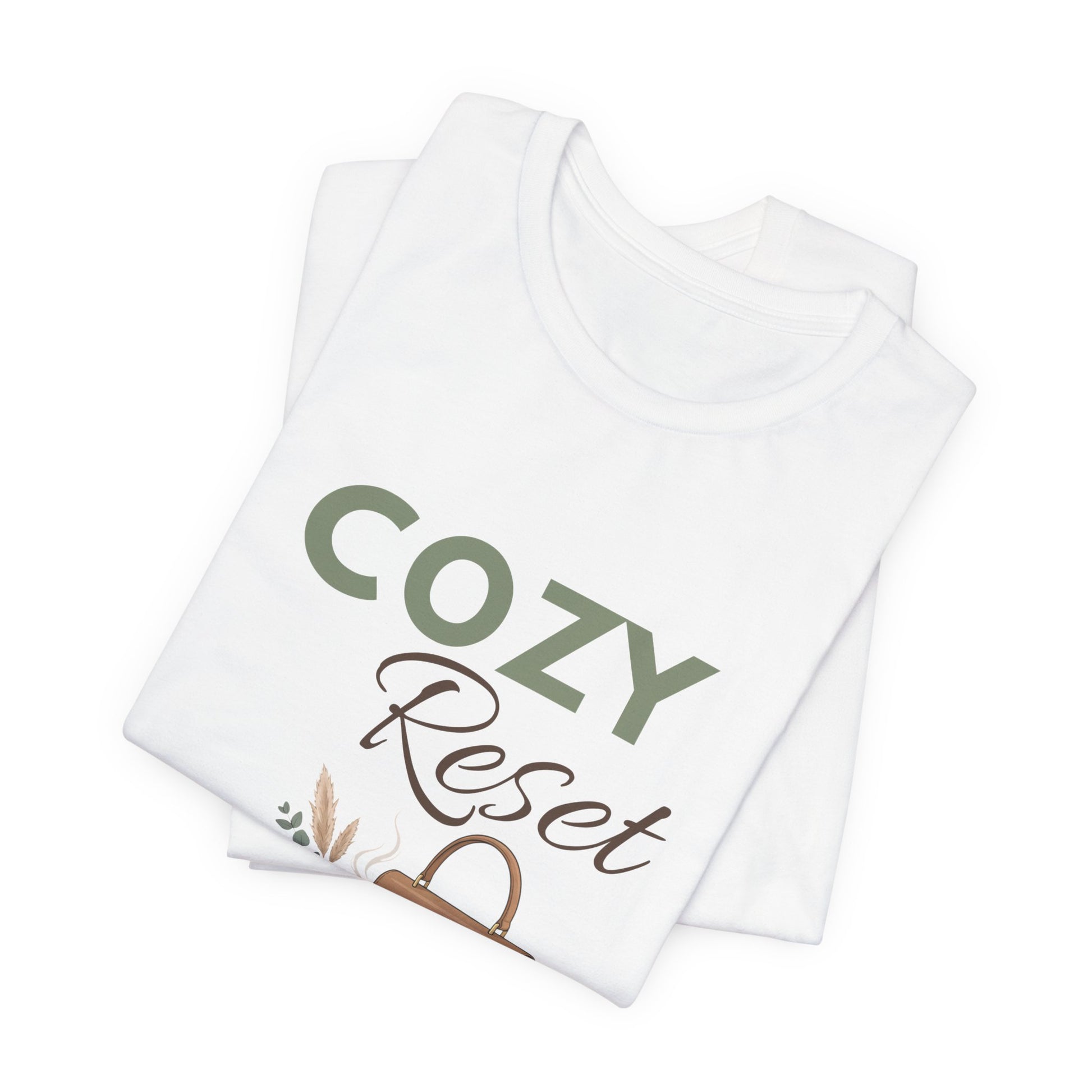 A folded white t-shirt with 'COZY Reset' on the front.