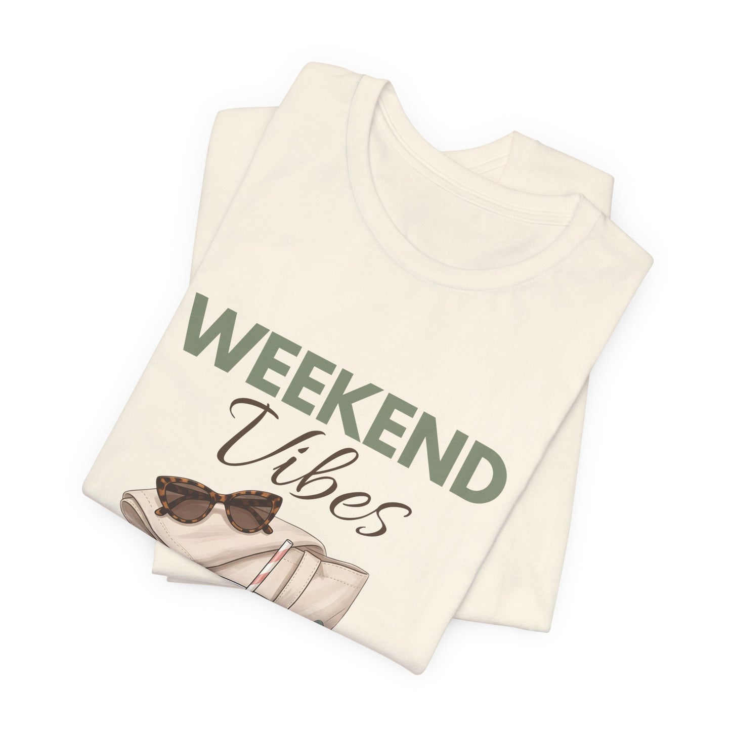 Folded natural colored t-shirt with 'Weekend Vibes' text and sunglasses graphic on a white background