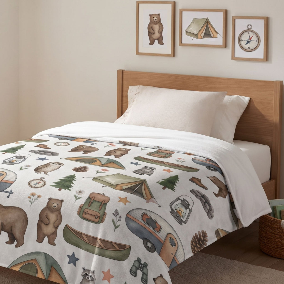 The minky blanket features a white background with a multicolor print of bears, tents, campfires, trees, and a camper van, paired with solid cream-colored sheets and matching pillowcases.
