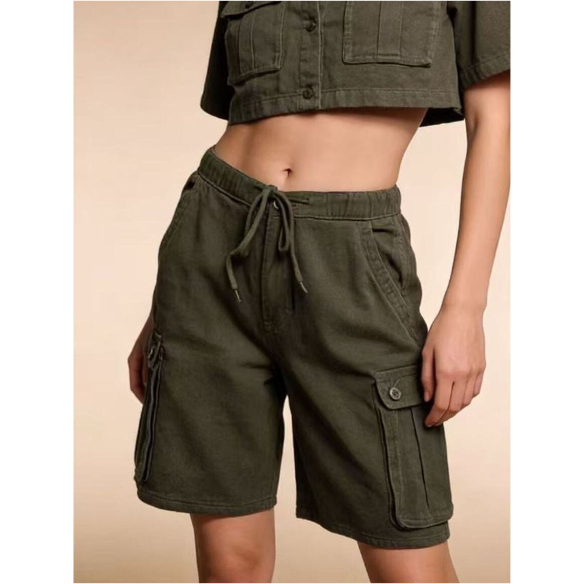 Green cargo shorts worn by a person on a beige background