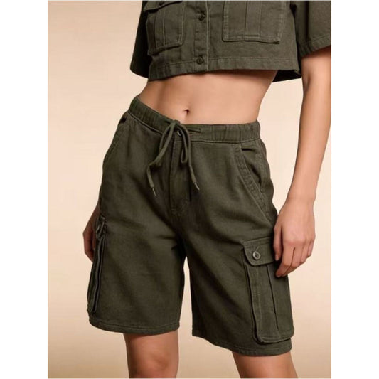 Green cargo shorts worn by a person on a beige background
