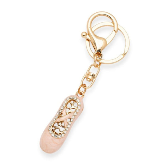 Gold and rose gold keychain with intricate design on a white background