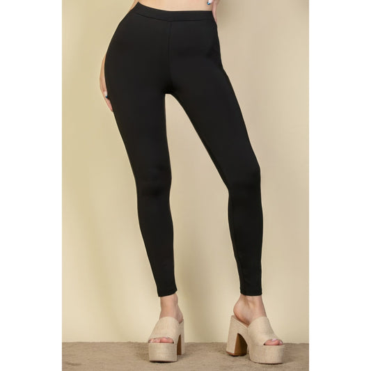 Black leggings worn by a person on a beige background
