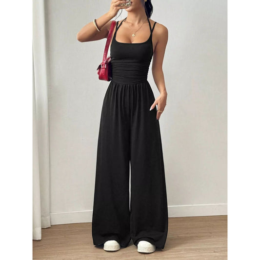 A woman wearing a black spaghetti strap wide leg jumpsuit.