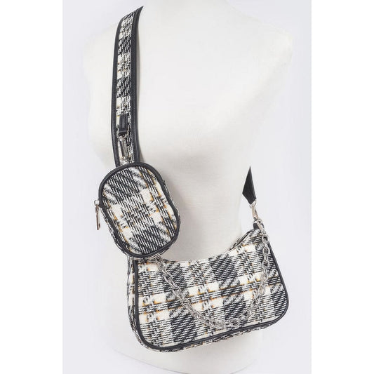A black tweed plaid shoulder bag with airpod on a mannequin.